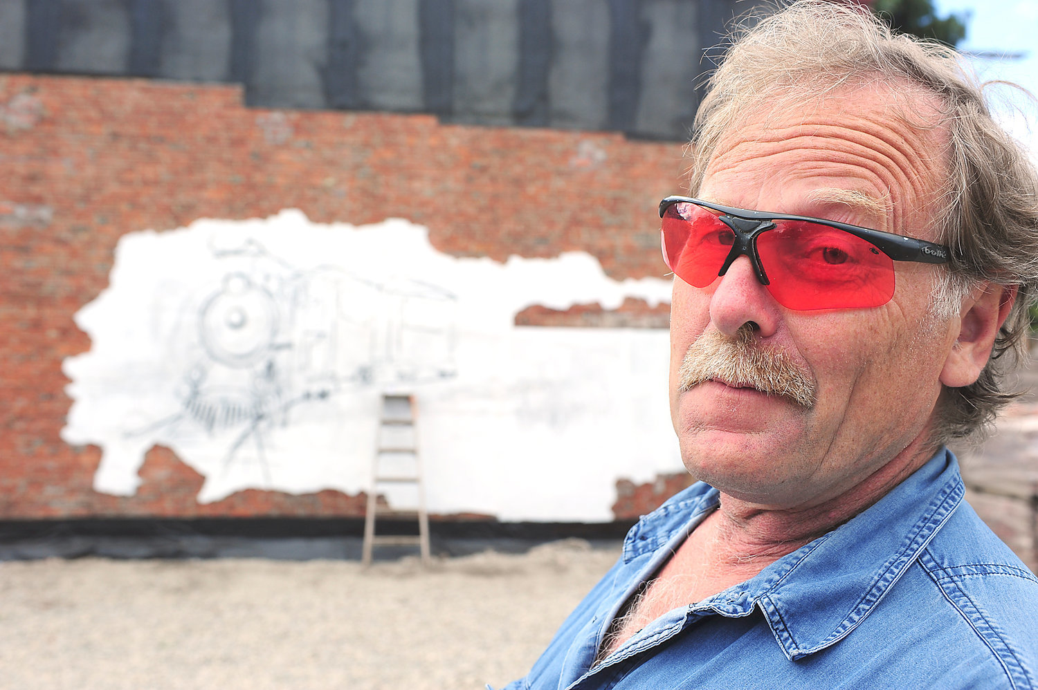Hank Claycamp takes a minute to describe the concept behind the mural he was working on on the side of a buliding on Tower Avenue in Centralia in this 2012 Chronicle file photo.